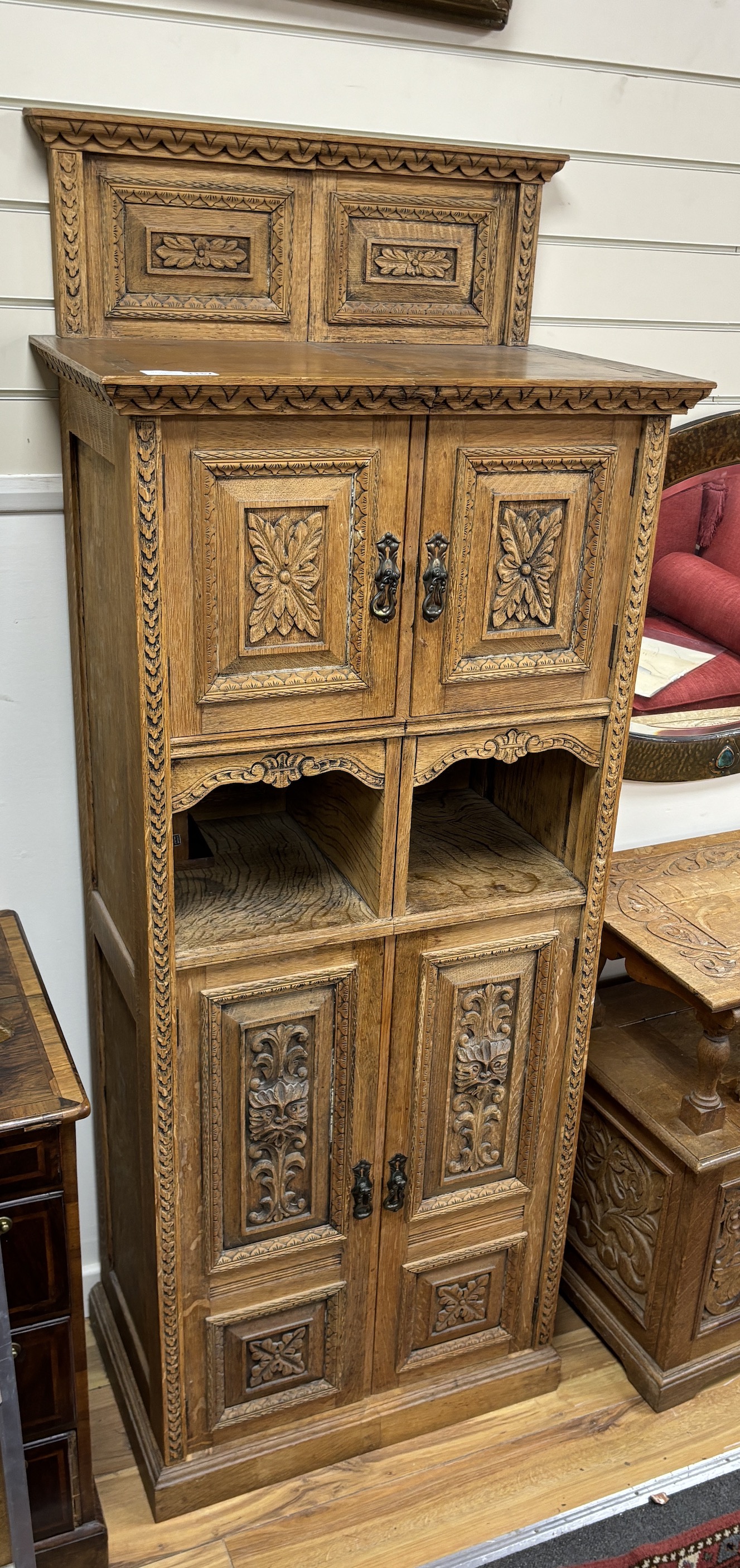 A late Victorian carved oak side cabinet, altered, width 68cm, depth 41cm, height 174cm